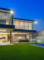 Two story home with glass windows, glass doors and glass pool fencing