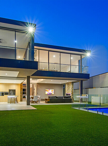 Two story home with glass windows, glass doors and glass pool fencing